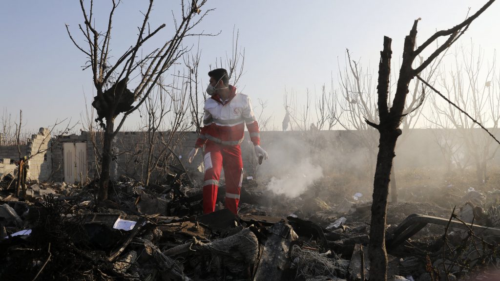 A rescue worker combs the wreckage of a Ukraine International Airlines plane near Iran's Imam Khomeini International Airport on Wednesday. All 176 people on board died in the crash, which Ukraine is now investigating. Ebrahim Noroozi/AP