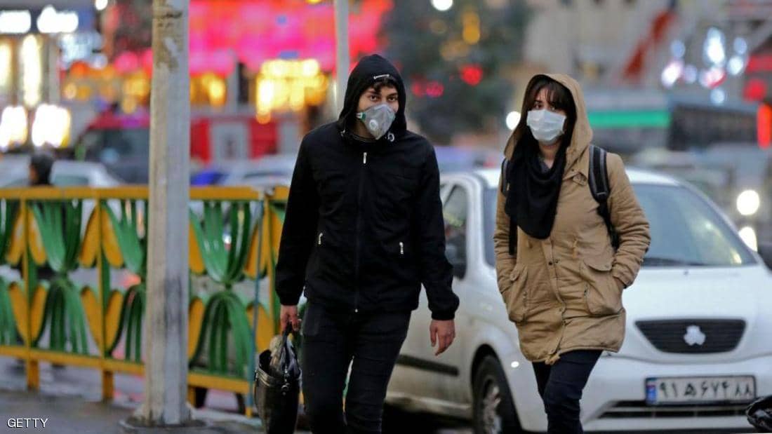 Two Iranians wear two masks for fear of infection with the Coronavirus/Getty
