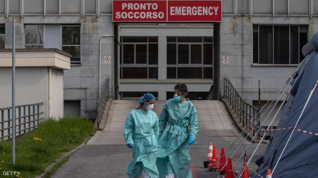 Two health workers in front of an Italian hospital