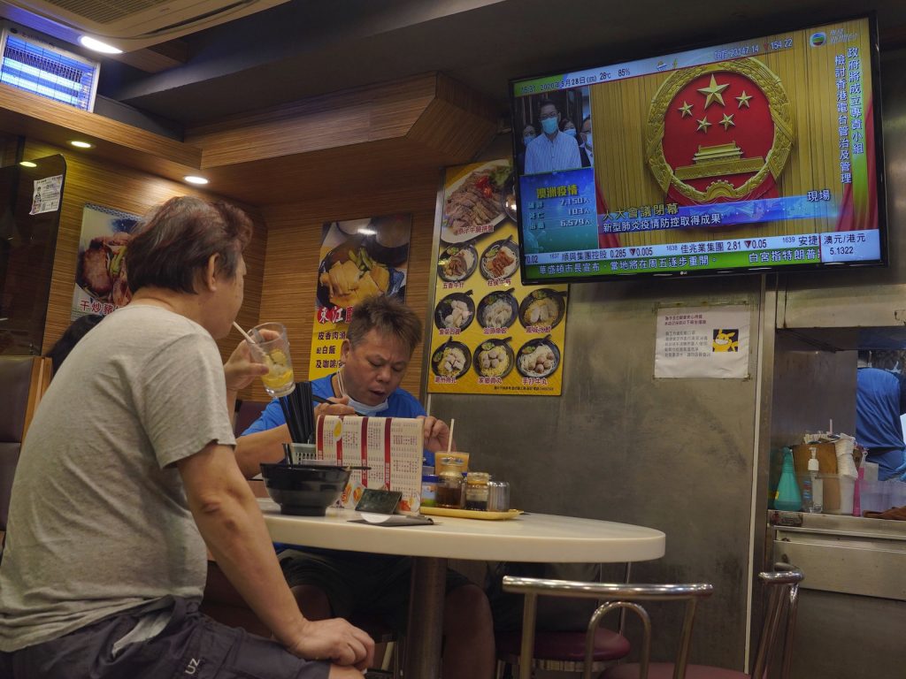 The closing session of China's National People's Congress plays on a television in a Hong Kong restaurant Thursday. Vincent Yu-AP